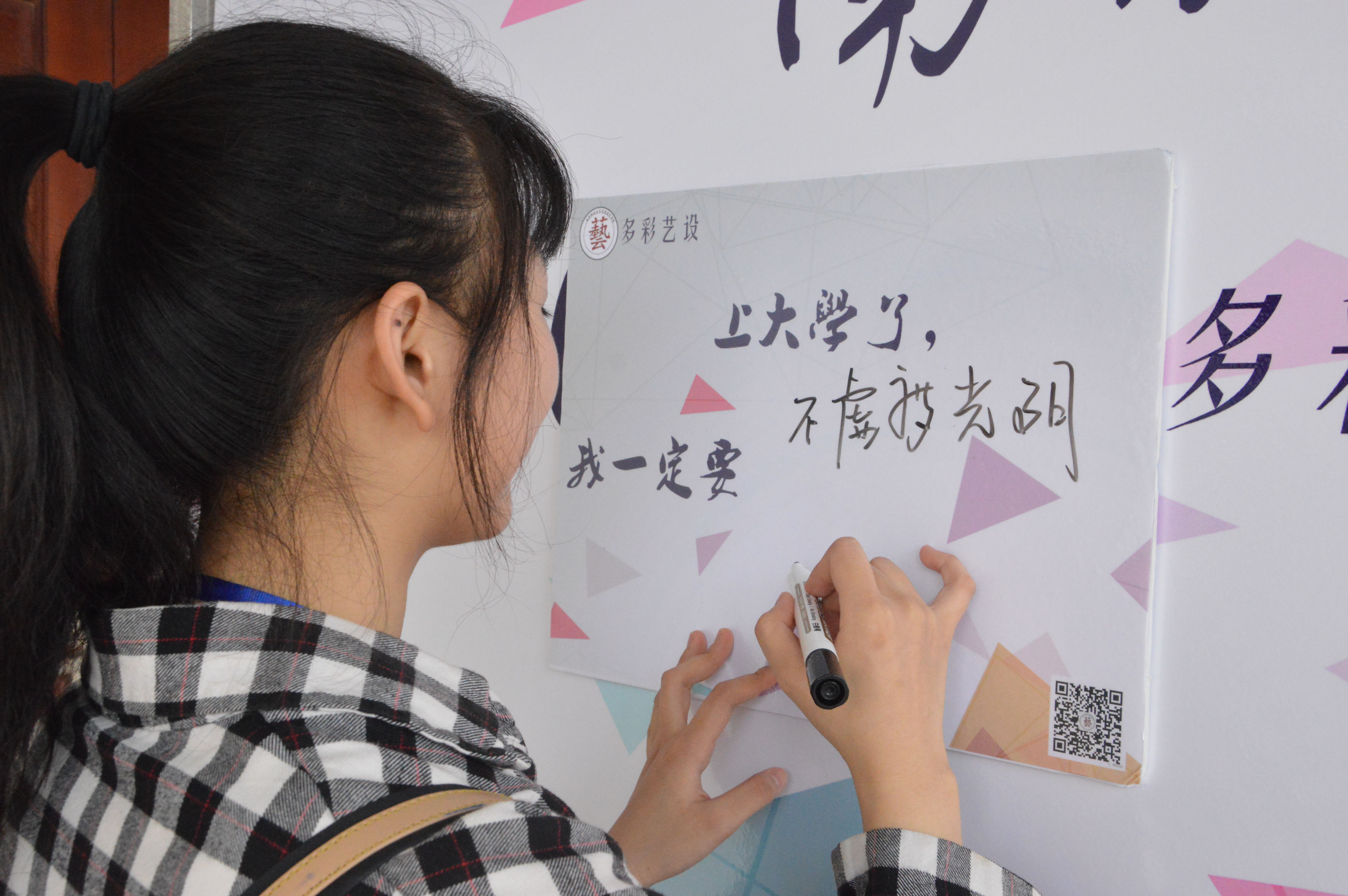 新生在“上大学了,我一定要……”的报到板上写下自己的大学梦想.jpg